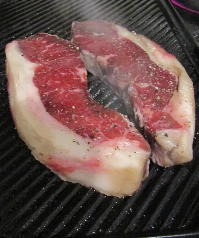 Carne a la parrilla en una plancha de cocina profesional